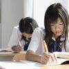 窓際の席で授業を受ける女子高生