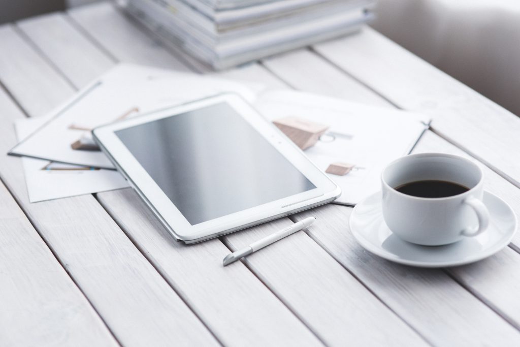 テーブルに置かれたタブレットとコーヒー