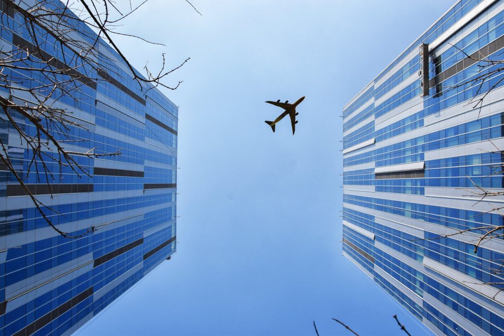 ビルと飛行機を見上げた写真